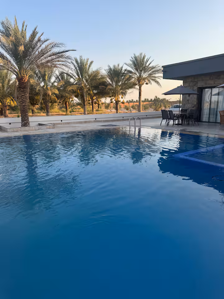 La piscine privée de la villa au milieu des palmiers de Biskra